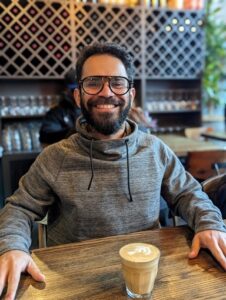 a man sitting at a table with a cup of coffee