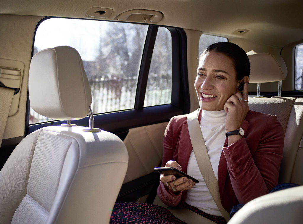 Soundscape - Lady in a taxi using Soundscape with earbuds