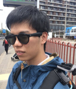 Soundscape - Close up image of Yuto stood outside a train station while wearing his Bose Frames