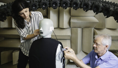 audio and acoustics: woman and man setting up a dummy in anachoic chamber