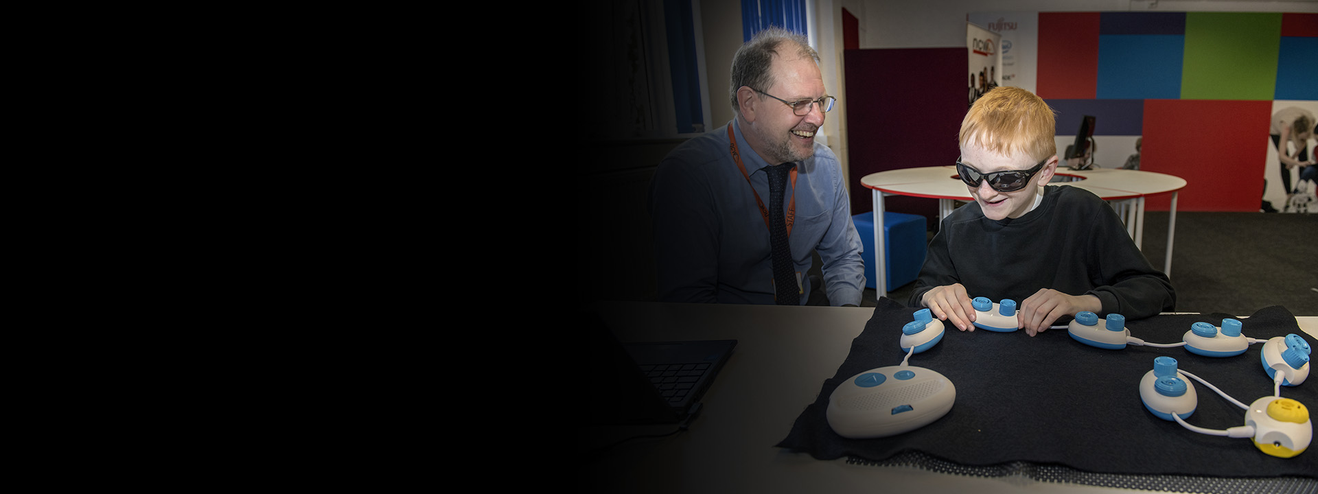 Young blind person learning to code tactilely using Code Jumper pods as teacher looks on. Photo by Jonathan Banks.