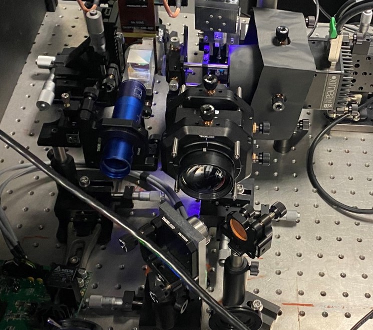 A workbench that shows a holographic storage experimental testbed, which includes an array of lenses, mirrors, and other components.