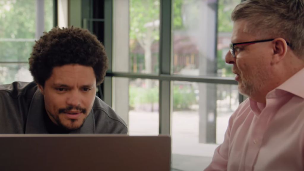 Two people talking in front of a computer