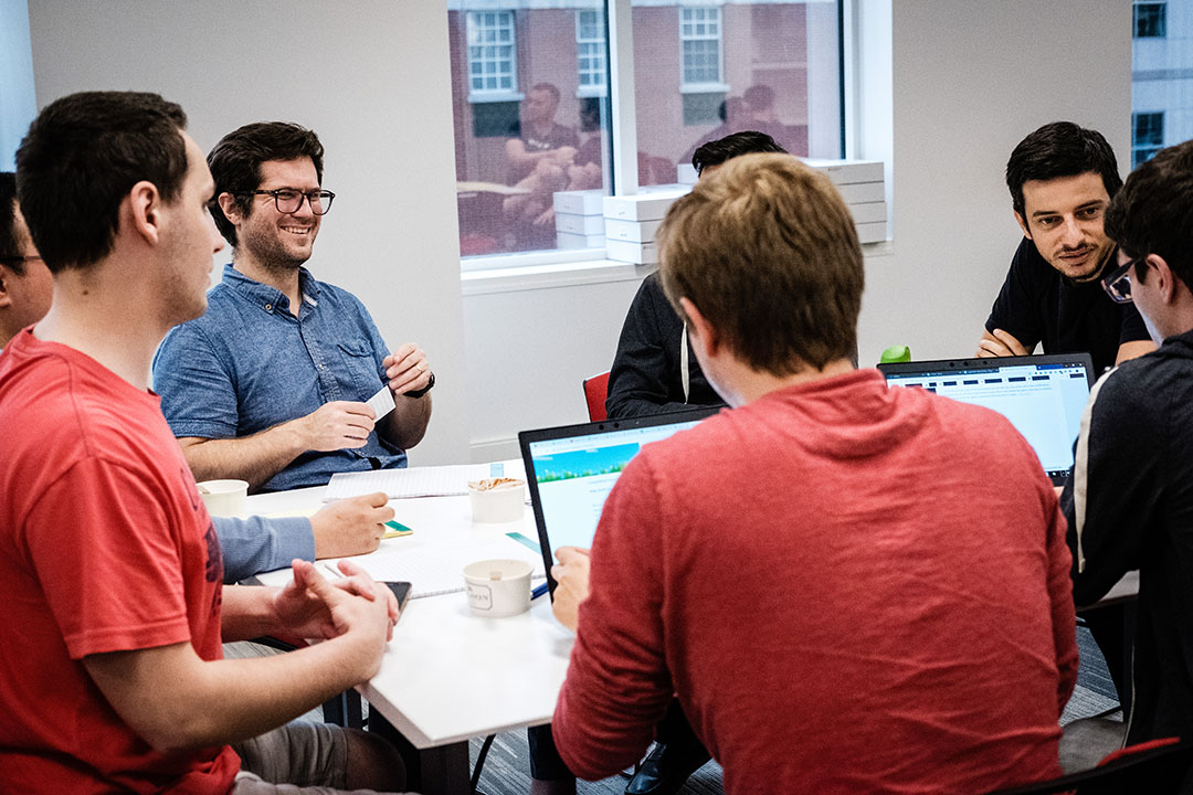 Microsoft Research Montreal researchers working together in a large office. Des chercheurs de Microsoft Research Montréal travaillent ensemble dans un grand bureau.