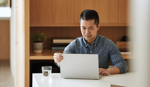 a man sitting at a table using a laptop