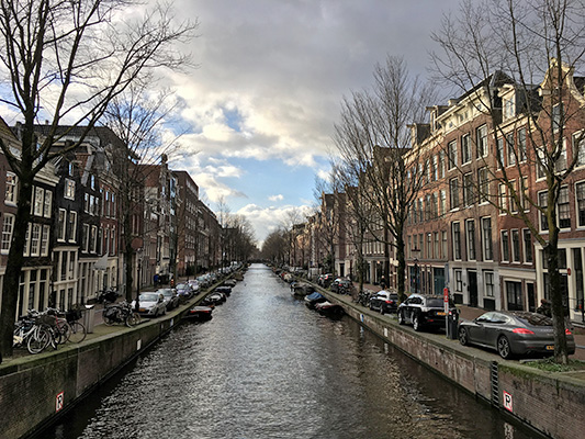 Soundscape - View down a treelined canal from a bridge, there are 3-5 story townhouses down either side.