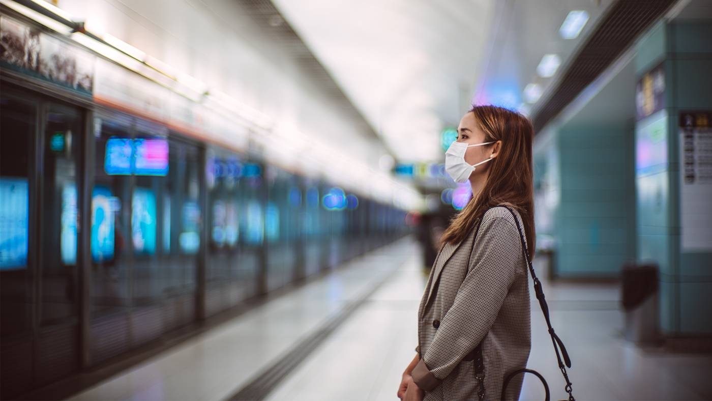 woman wearing a face mask waiting in the subway