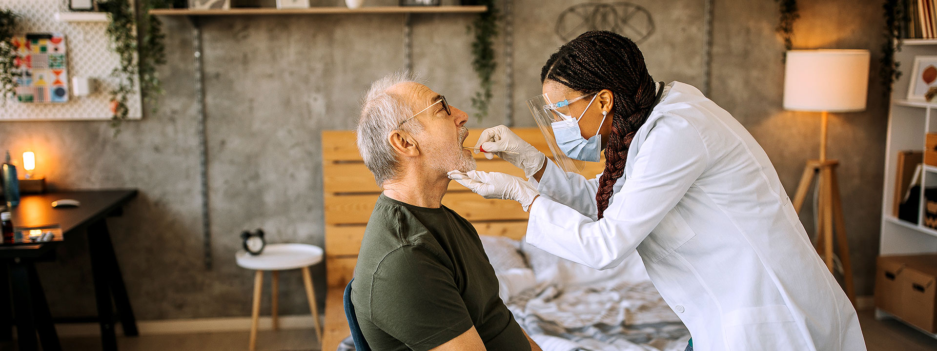 woman wearing a surgical mask swabbing the inside of an elderly man's nose