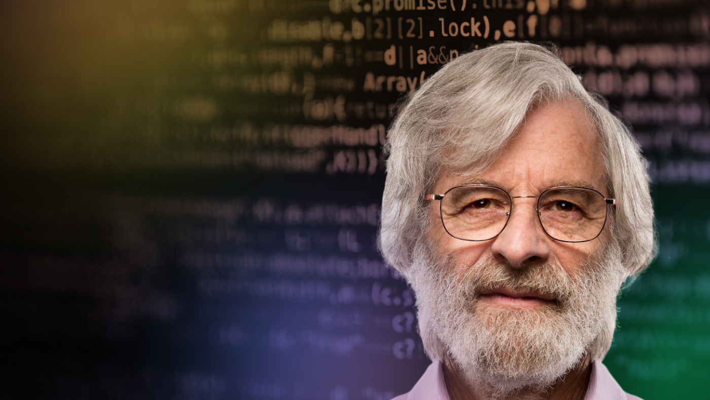Leslie Lamport headshot in front of blurred code