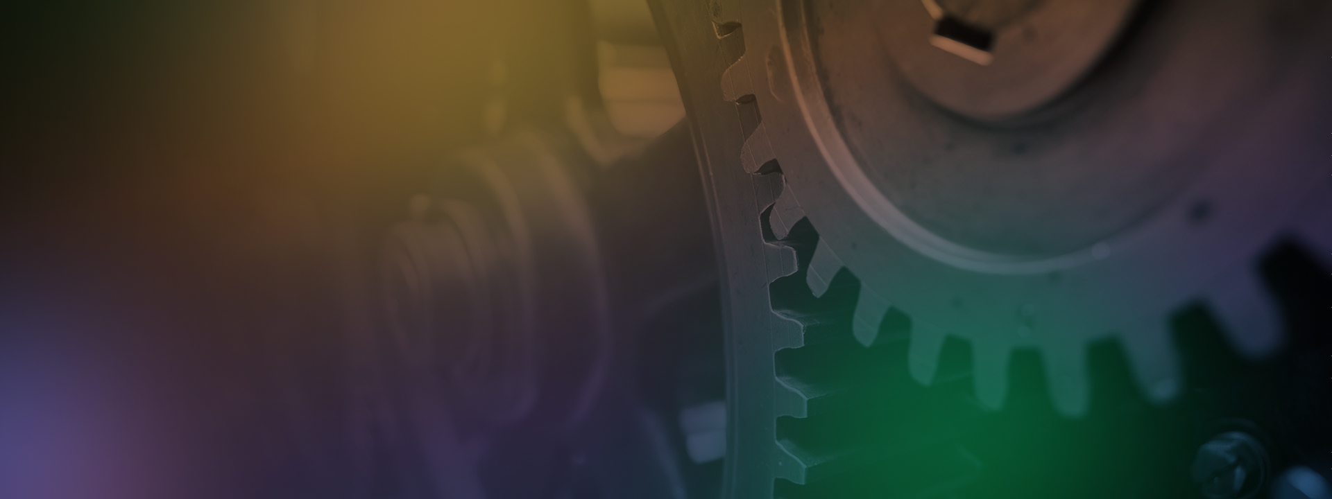close-up image of interlocking gears turning with a rainbow gradient overlay
