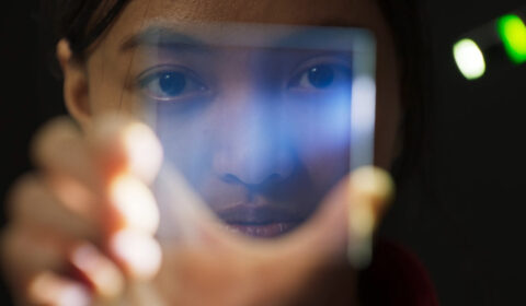 woman holding glass in front of her face