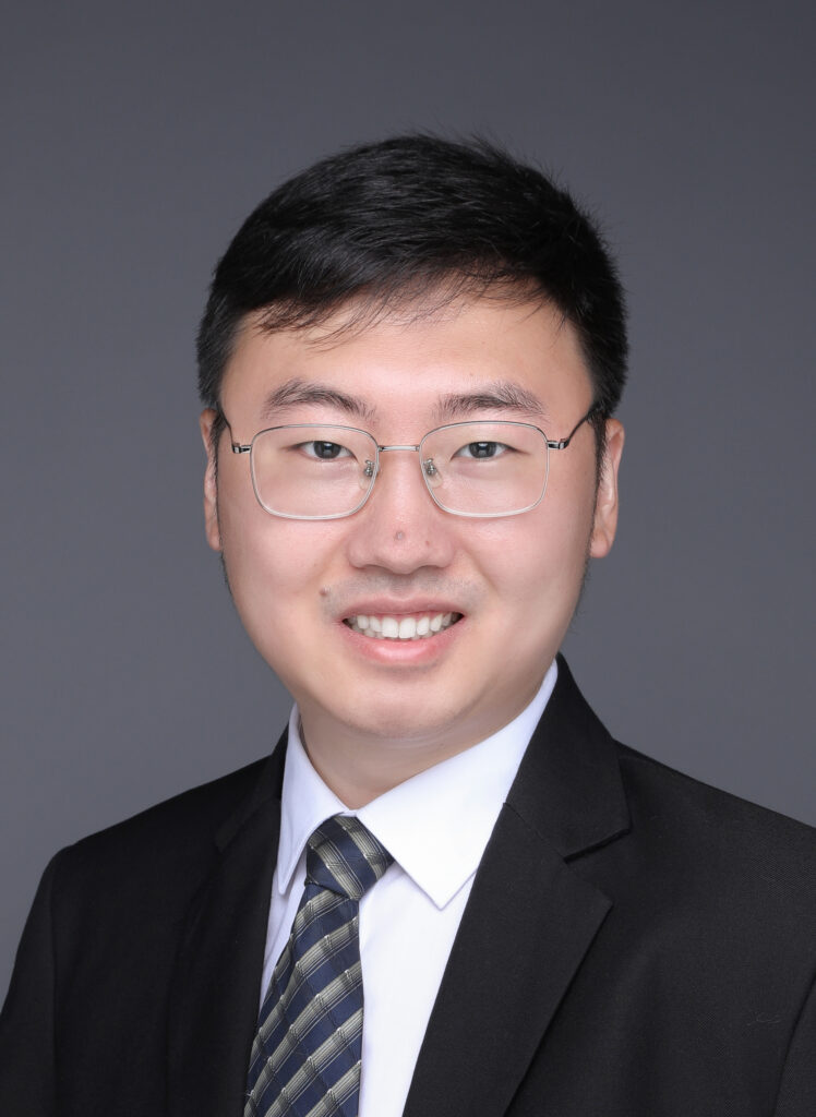 a man wearing a suit and tie smiling at the camera