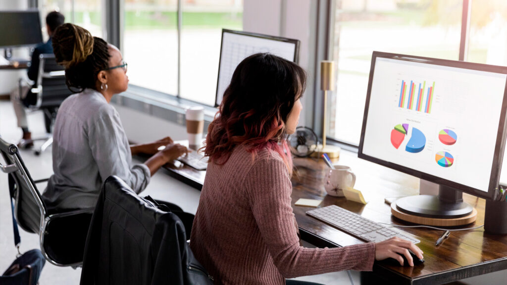 AI4Good - Expand Opportunity | photo of two women in front of computer screens