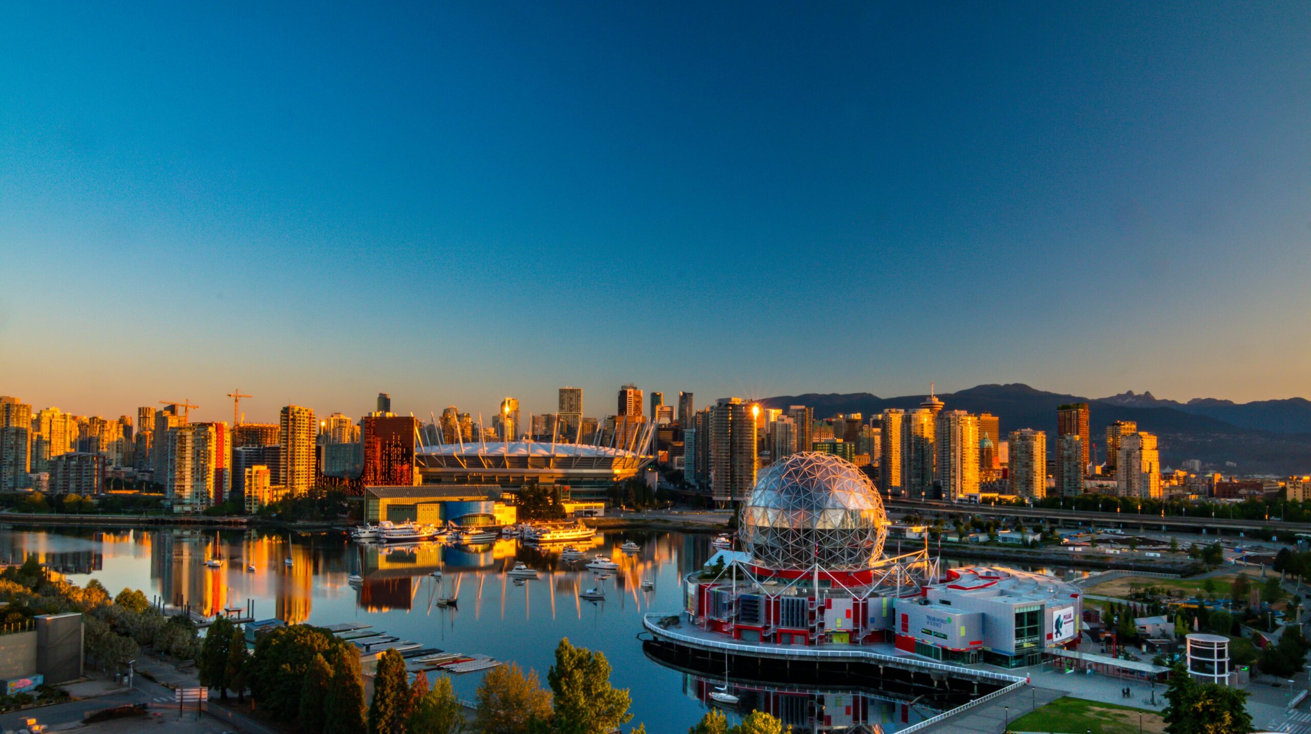 a bridge over a body of water with the Vancouver downtown in the background