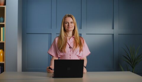 a woman standing in front of a laptop