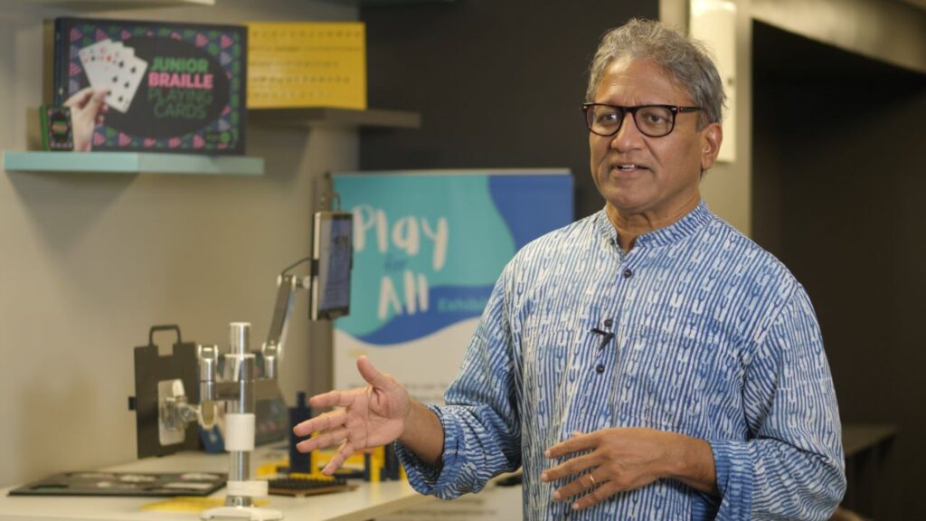 Swami Manohar standing in front of a table