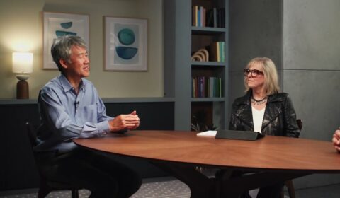 Peter Lee and Gretchen Huizinga sitting at a table having a discussion with Vijay Mital