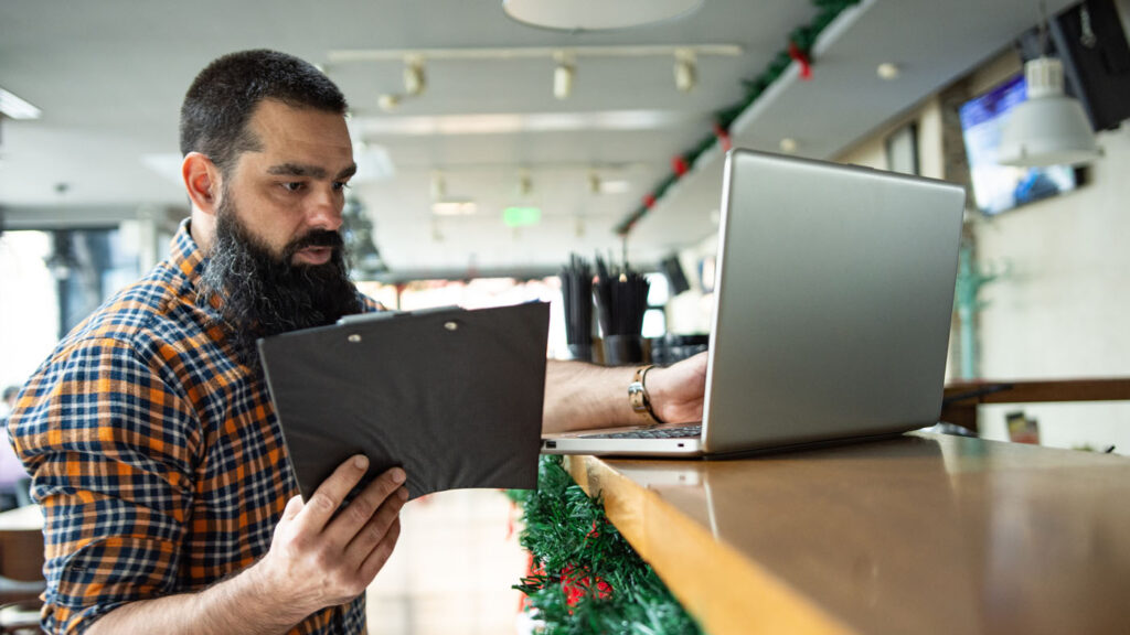 AI4Good - Expand Opportunity | man looking at a tablet and a laptop