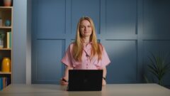 a woman standing in front of a laptop