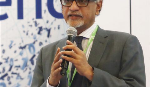 P. Anandan wearing a suit and tie talking on a cell phone