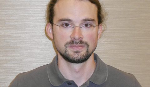 a man wearing glasses posing for the camera