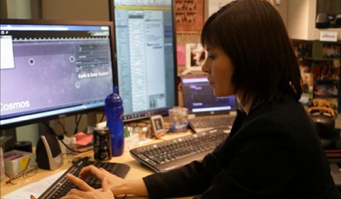 a person sitting at a desk in front of a laptop computer