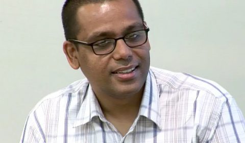 a man in glasses looking at the camera