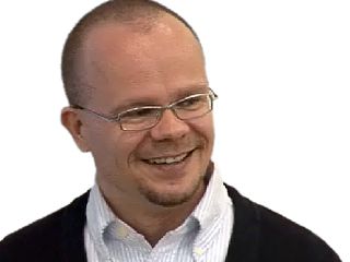 a man wearing glasses and smiling at the camera