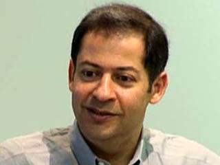 Noshir Contractor wearing a suit and tie smiling at the camera