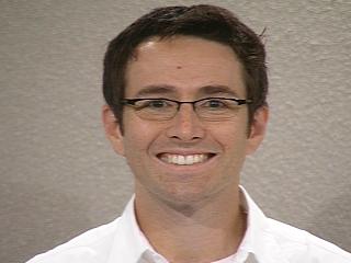 Donald J. Patterson wearing glasses and smiling at the camera