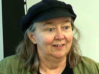 a woman wearing a hat and smiling at the camera