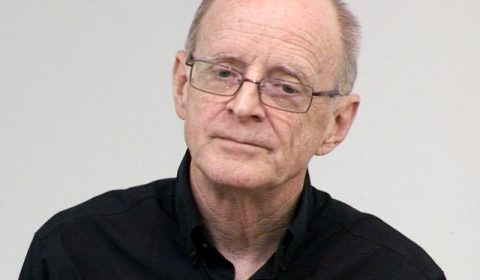 James W. Pennebaker wearing glasses and smiling at the camera