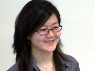 a woman wearing glasses and smiling at the camera