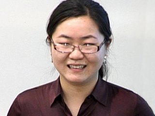 a man wearing glasses and smiling at the camera