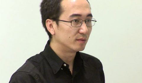 a man wearing glasses and looking at the camera