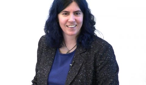 Tamara Munzner wearing a purple shirt and smiling at the camera