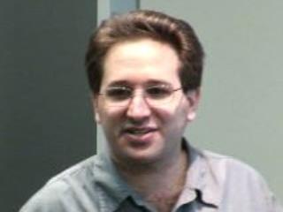 Scott Aaronson wearing glasses and smiling at the camera