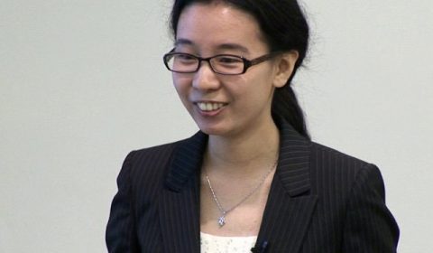 a person wearing glasses and smiling at the camera