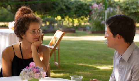 a man and a woman sitting at a picnic table