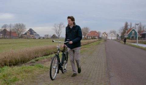 a man riding a bike down a dirt road