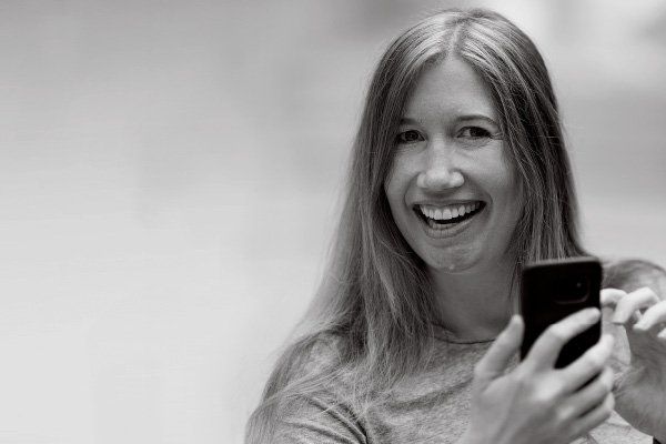 a woman holding a phone and looking at the camera