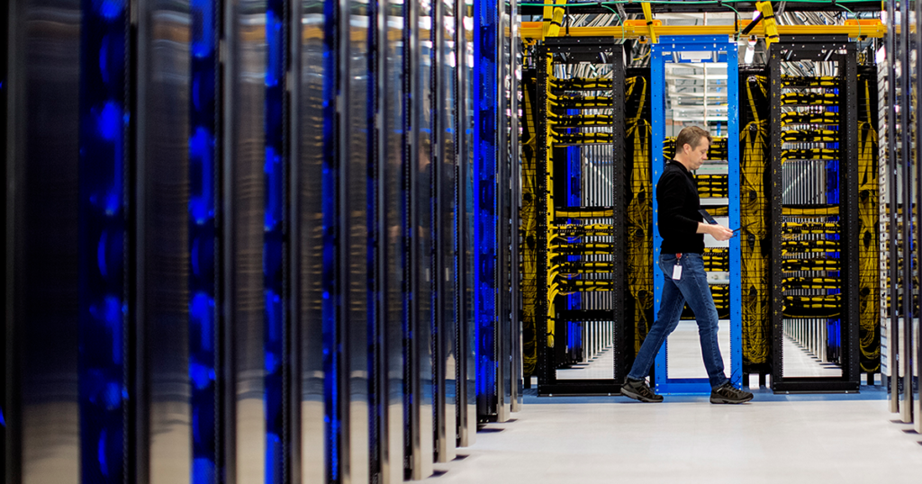 Image of a worker walking through a datacenter.