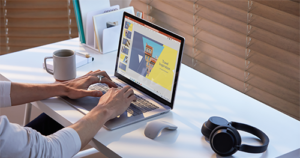 A photograph of Male working on Surface Laptop 3 in PowerPoint with Surface Mouse and Surface Headphones.