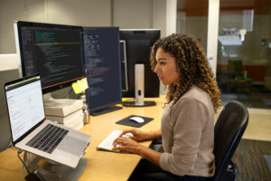 Black female developer working at enterprise office workspace.