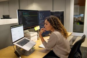 Black female developer working at enterprise office workspace.