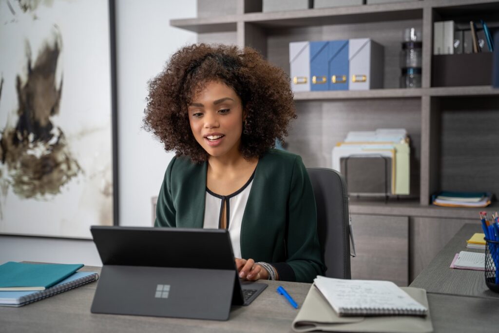 An interior design expert using Microsoft Teams on a Surface laptop to remotely assist an onsite retail store manager using Dynamics 365 Remote Assist on HoloLens 2 to design the layout of the store.