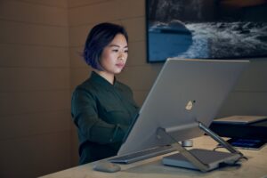 Adult female working on desktop monitor.