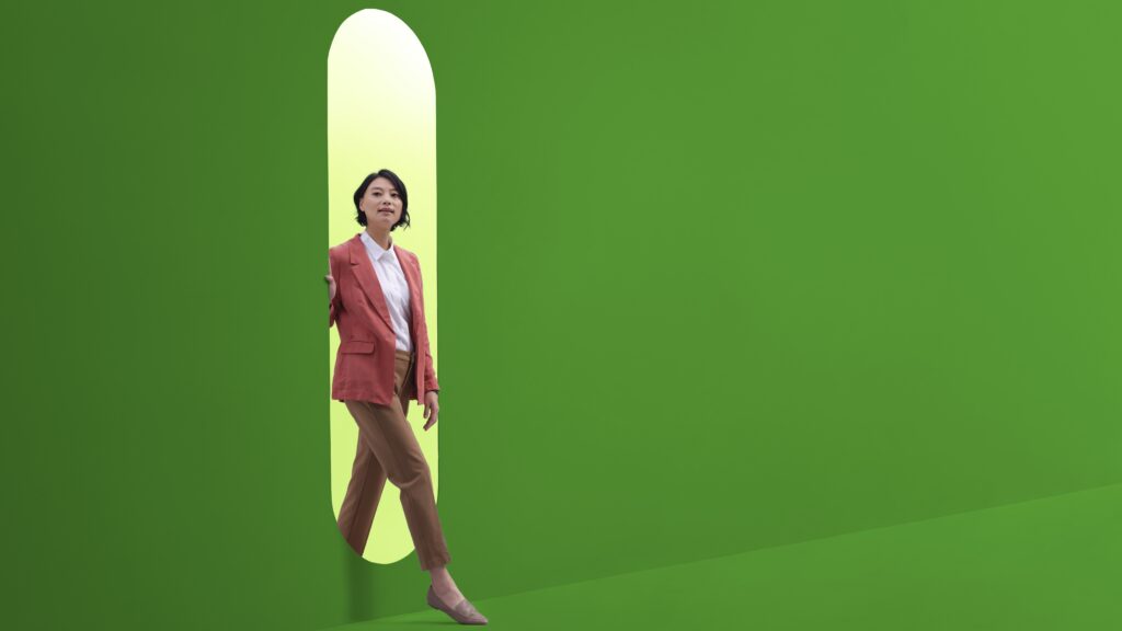 Woman entering a green room through an oval with lighter green behind her.
