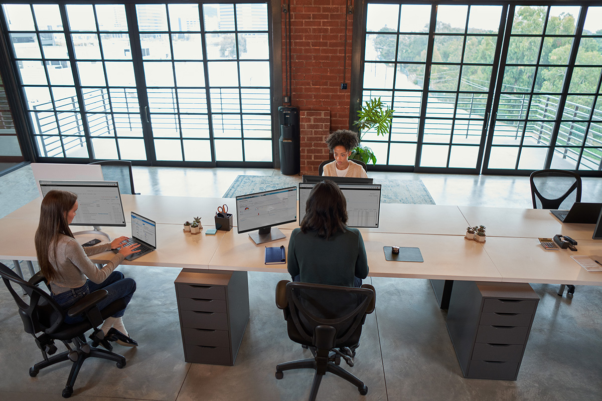 Photo of enterprise office workers in focused work in an open work space.