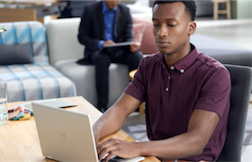 a group of people sitting at a table with a laptop